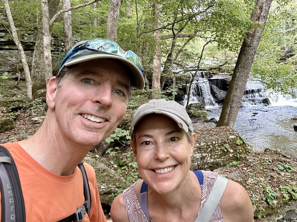 Drs. Lori and Chris King hiking near a waterfall